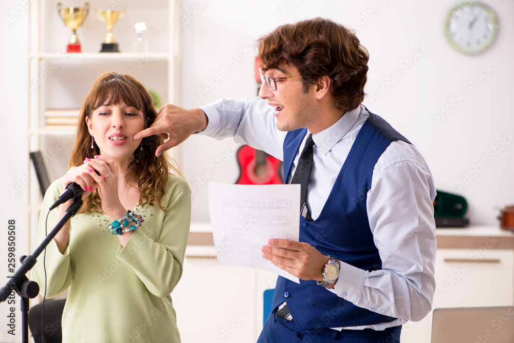 Obraz premium Young woman during music lesson with male teacher