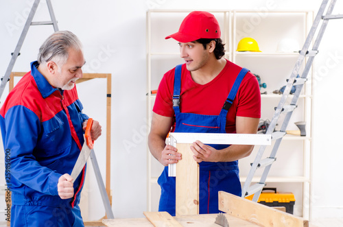 Two professional contractors laying flooring at home 