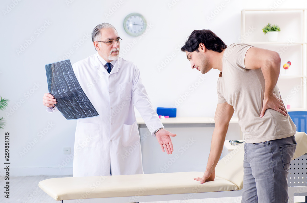Obraz premium Young man visiting old male doctor radiologist 