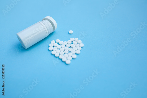 medicine, healthcare and pharmacy concept - pills and of drugs in shape of the heart