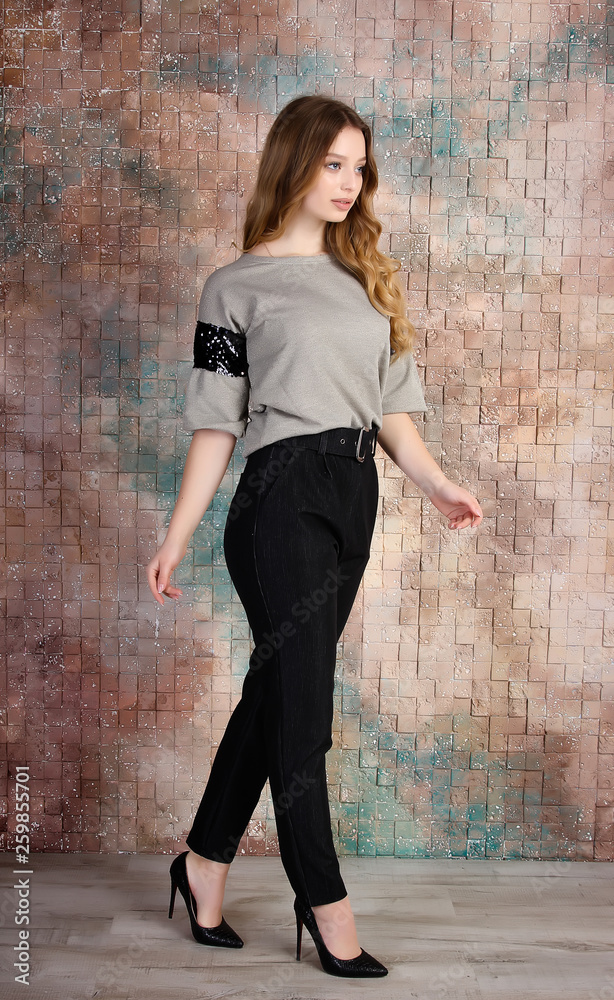 Business woman in pants and shirt on brick wall background. Office and business style. Studio photo. 