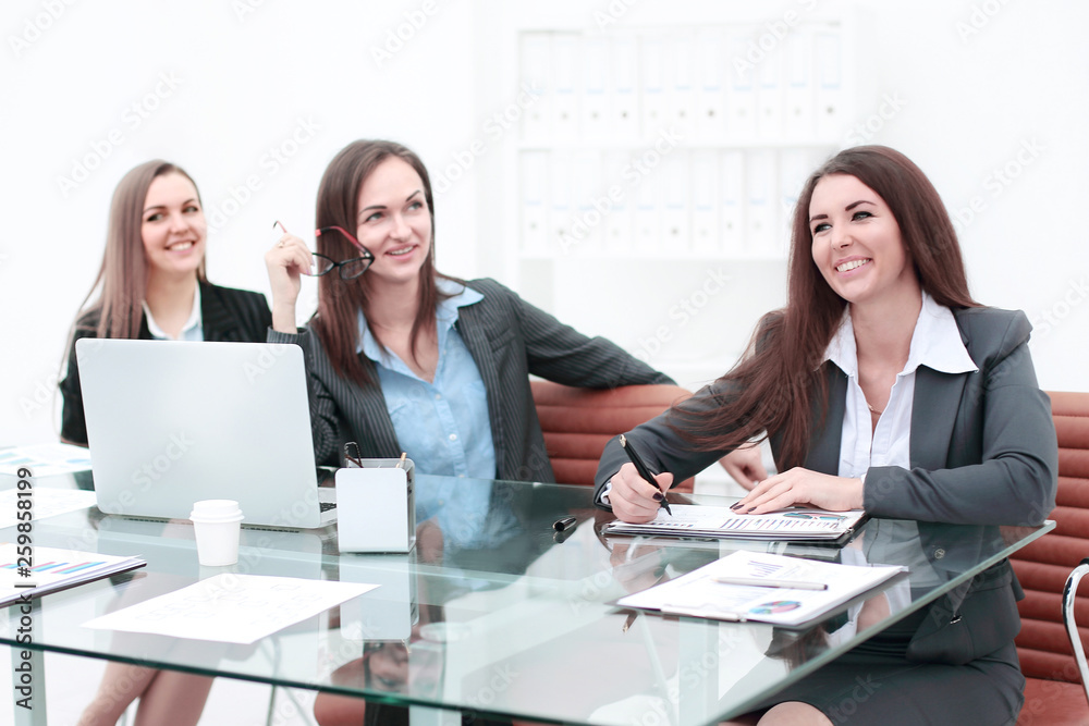 Three Businesswomen Meeting Around Table In Modern Office Three Businesswomen Meeting Around Table In Modern Office