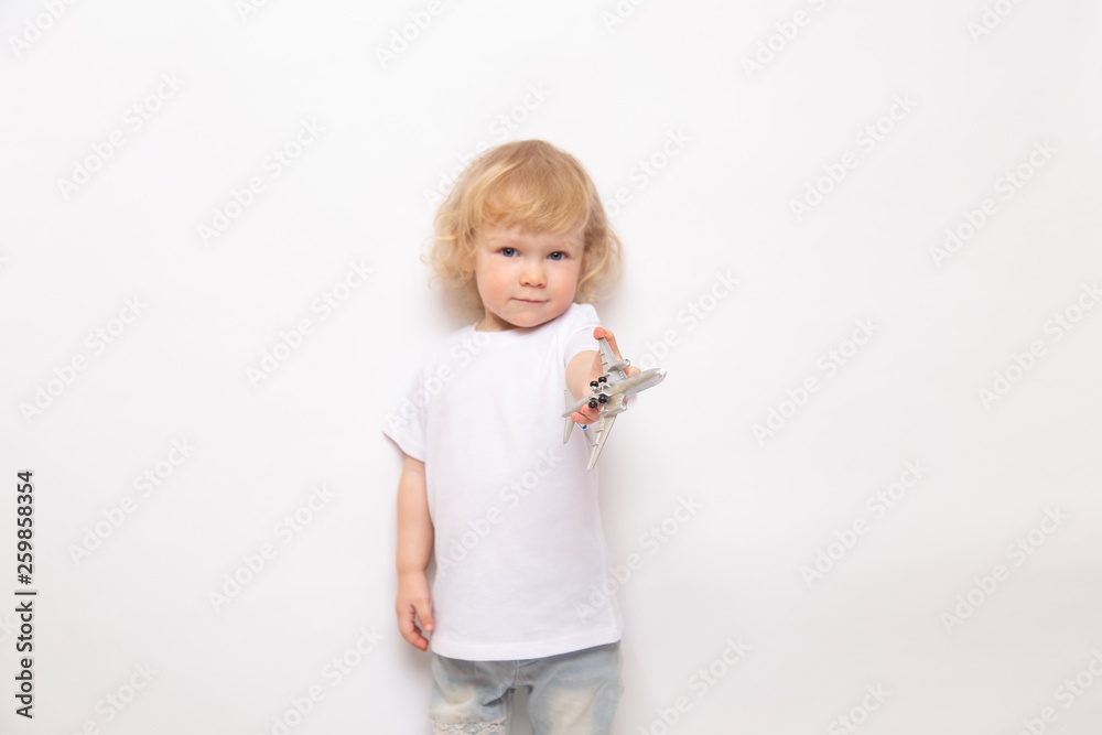 child playing with toy airplane against on a white background. concept dreams of flight child playing with toy airplane against on a white background. concept dreams of flight