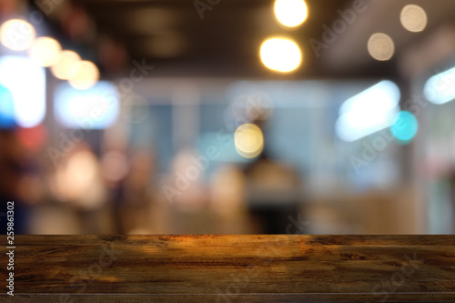 Empty dark wooden table in front of abstract blurred bokeh background of restaurant . can be used for display or montage your products.Mock up for space.