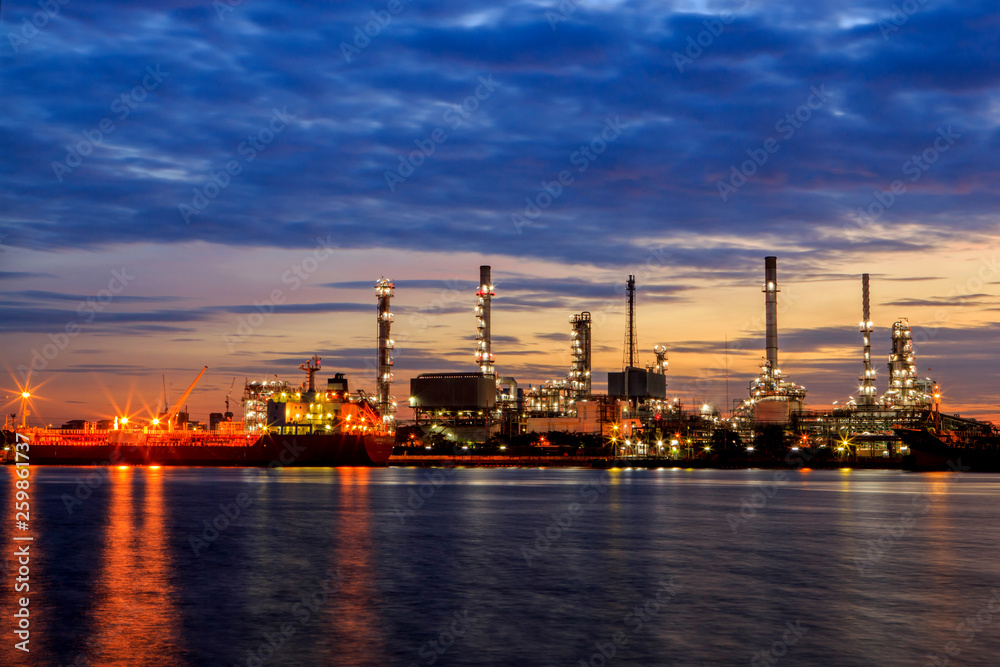 Fototapeta premium Oil refinery with water reflection before sunrise
