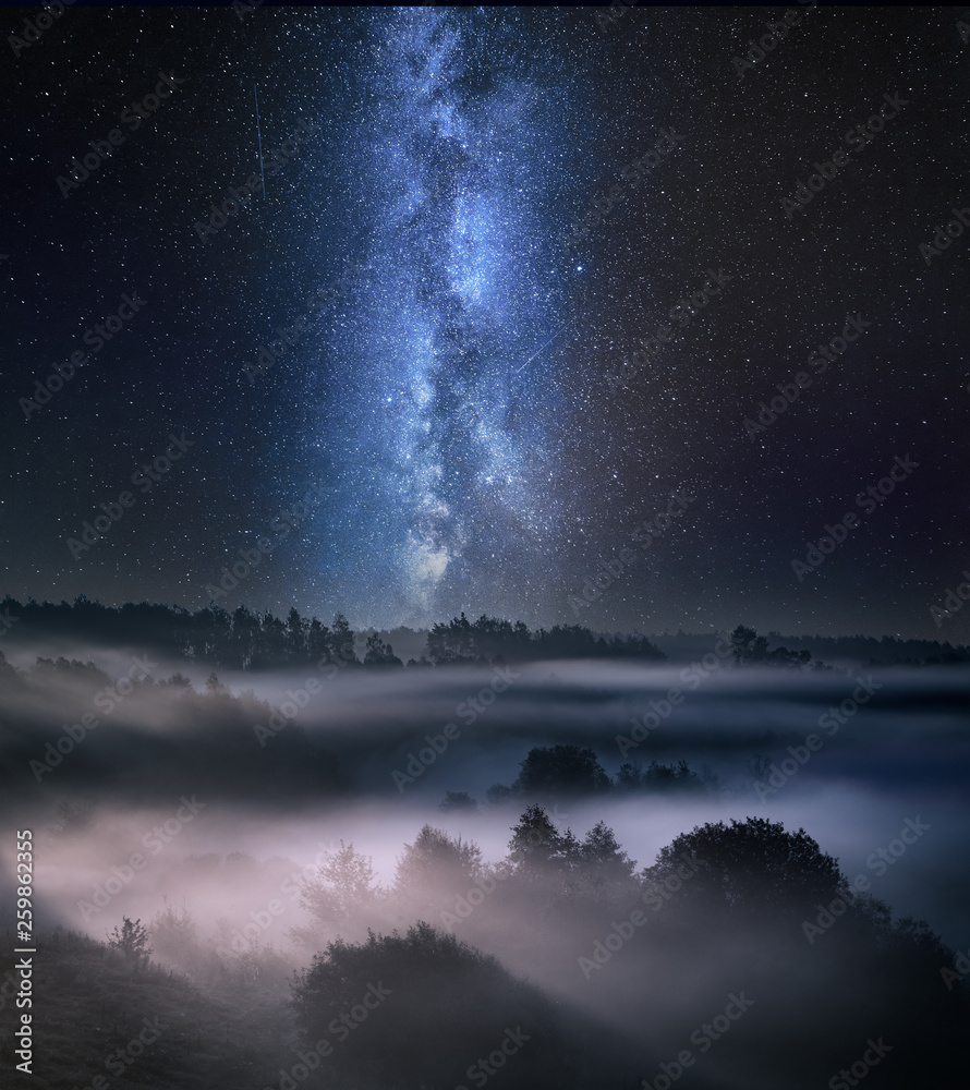 Wonderful foggy valley at night with milky way