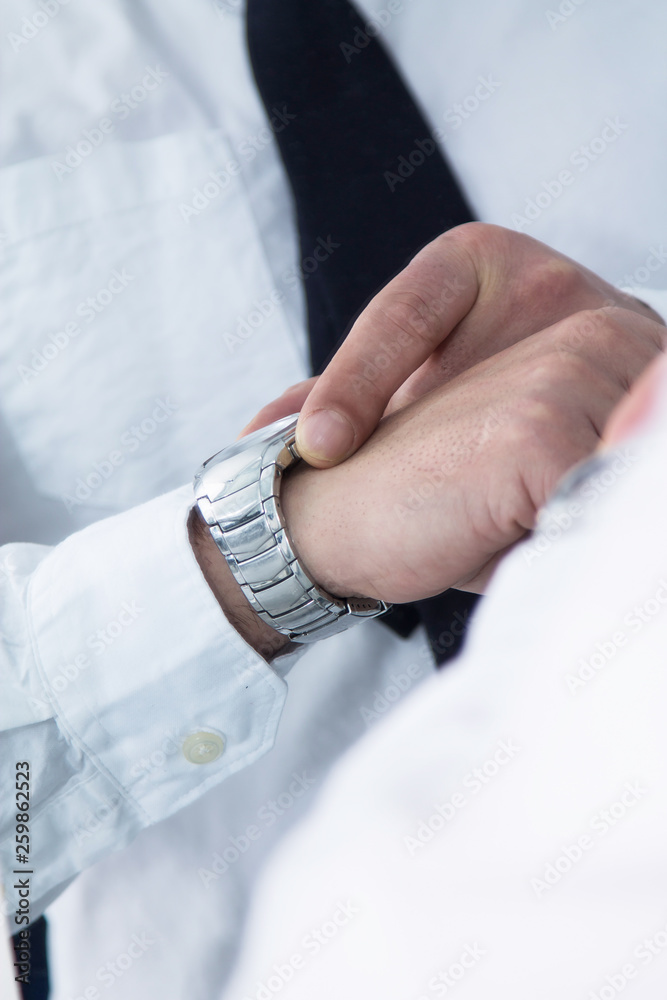 man placing clock on his wrist in front of the mirror