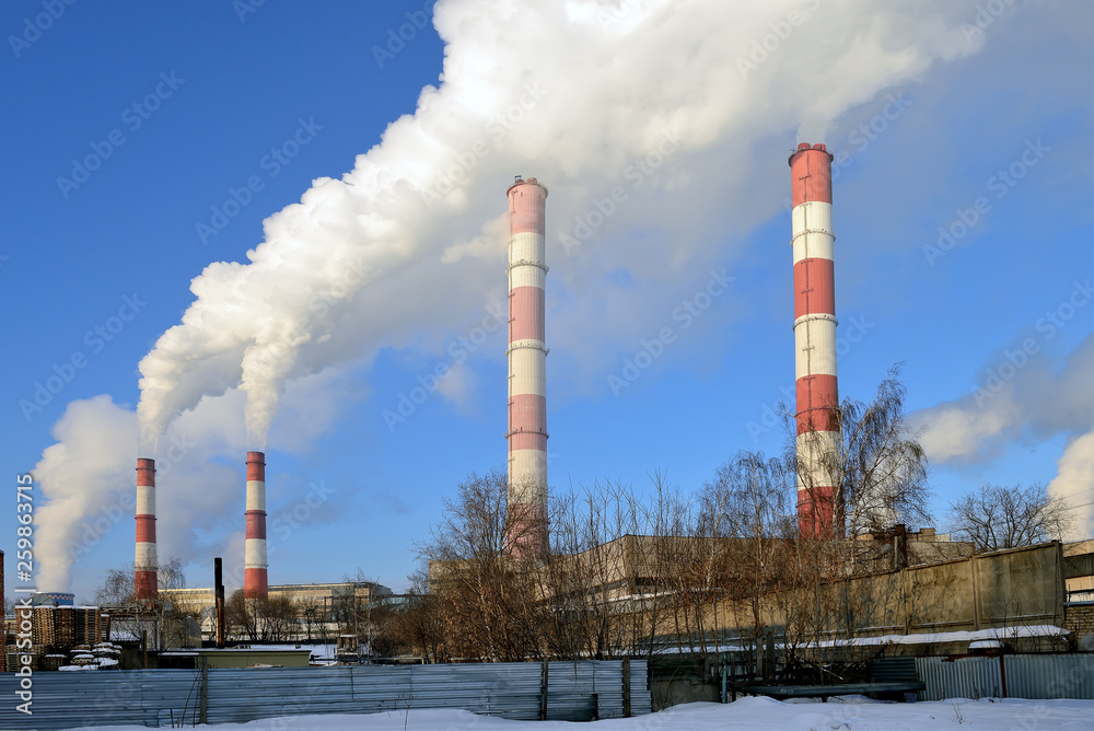 Thermal power plant, smoke from the chimney against blue sky