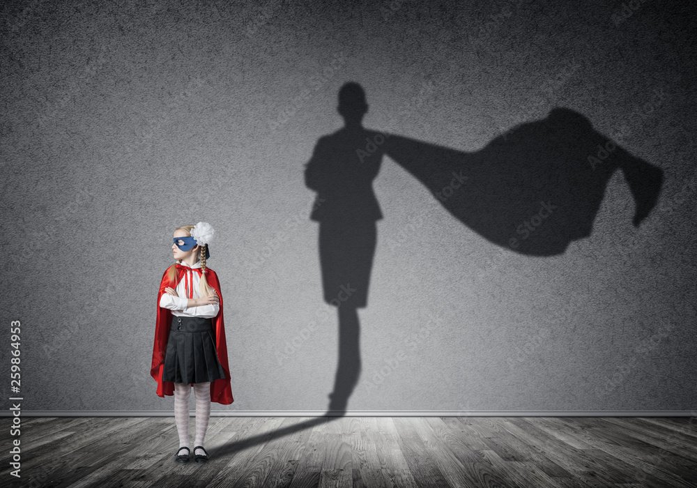 Girl power concept with cute kid guardian and shadow on wall. Mixed media