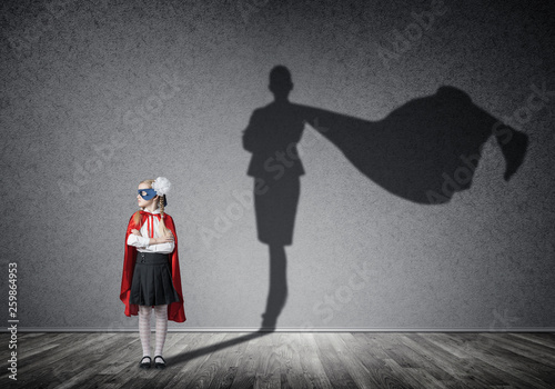 Obraz na płótnie Girl power concept with cute kid guardian and shadow on wall. Mixed media w salonie