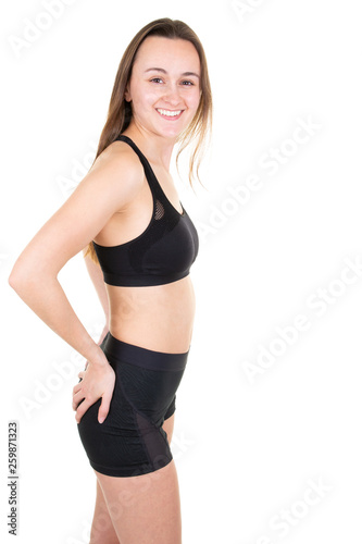 Happy young girl wearing sports clothing standing posing in white studio