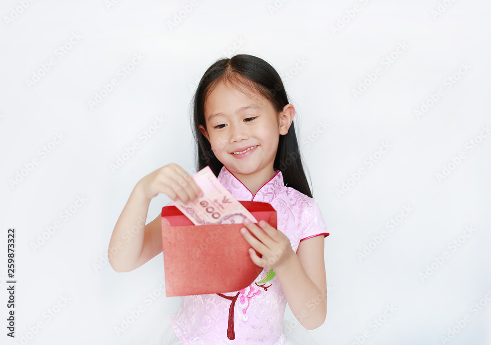 Happy little Asian child girl wearing pink traditional cheongsam dress smiling while receiving Chinese New Year red envelope packet with money on white background. Happy chinese new year concept. Happy little Asian child girl wearing pink traditional cheongsam dress smiling while receiving Chinese New Year red envelope packet with money on white background. Happy chinese new year concept.