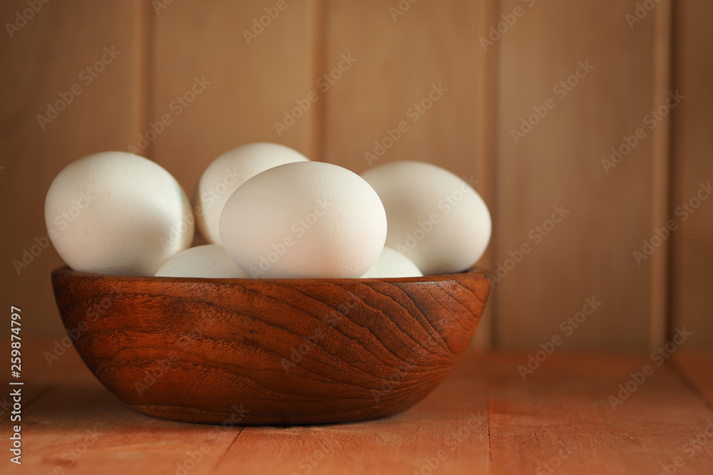 Chicken eggs in a wooden bowl on a wooden surface. Easter Chicken eggs in a wooden bowl on a wooden surface. Easter