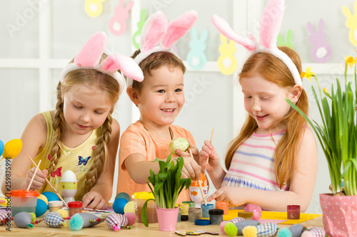 funny cute kids painting Easter eggs at home. adorable children prepare for easter