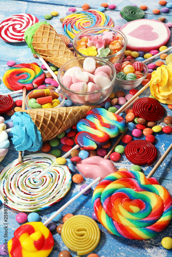 candies with jelly and sugar. colorful array of different childs sweets and treats on blue