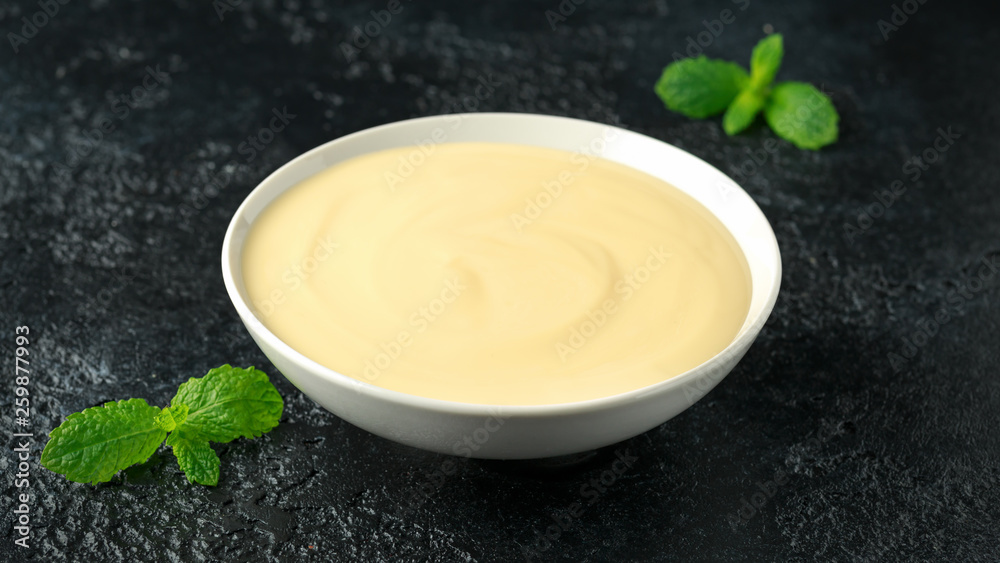 Bowl of vanilla custard on rustic background Bowl of vanilla custard on rustic background