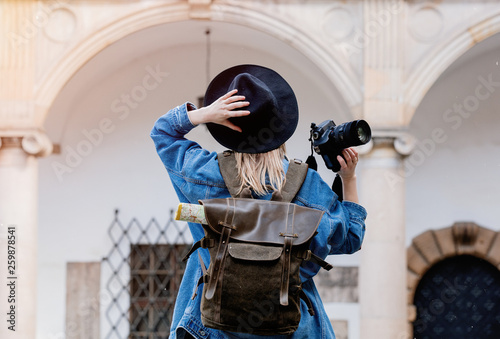 Young woman, professional photographer with camera in old castle