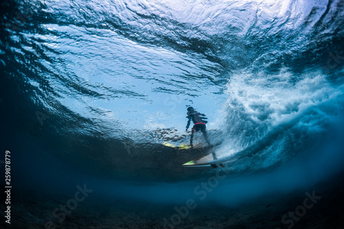 Underwater view of the surfer riding the crystal clear ocean wave © Dudarev Mikhail