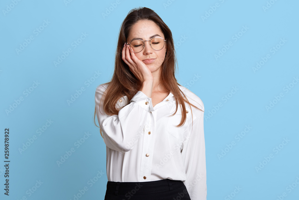 Portrait of exhausted sleeping businesswoman holding her head with closed eyes on right hand. Attractive young female enjoys short rest after hard tiresome working day. Cope space for advertisement. Portrait of exhausted sleeping businesswoman holding her head with closed eyes on right hand. Attractive young female enjoys short rest after hard tiresome working day. Cope space for advertisement.