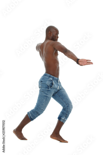 Athletic young black man in jeans and with a nude torso dancing isolated on white background.