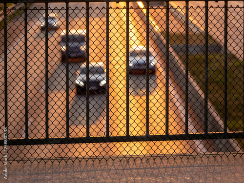 Image of metal safety barrier on brigde above highway with blurry cars in the background