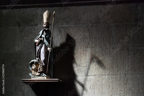 Fotografia Figure of a bishop throwing a shadow of a grimreaper