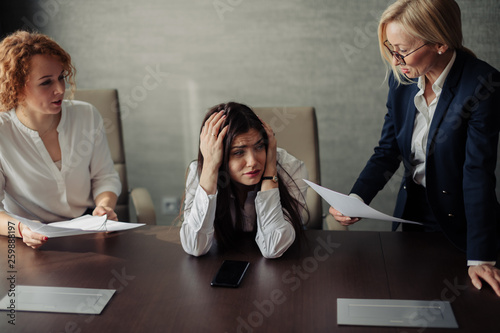 Young female office manager unable to cope with too many tasks from her boss and supervisor, suffering stress, pressing her head with desperate expression.