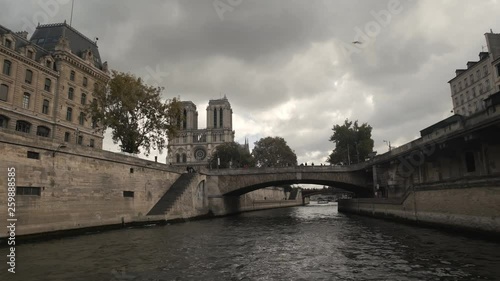 Point of view from a boat cruise tourist on Seine River Bridge of Notre Dame cathedral gothic catholic church Paris, France 