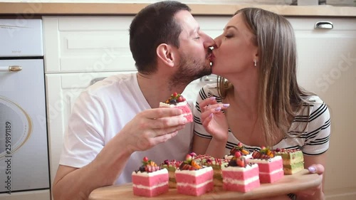 Happy, romantic couple in love having dessert together, eating sweets at kitchen