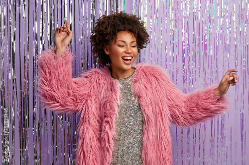 Tableau sur toile Inspired curly woman dances at disco party, sings song, dressed in sparkling dre