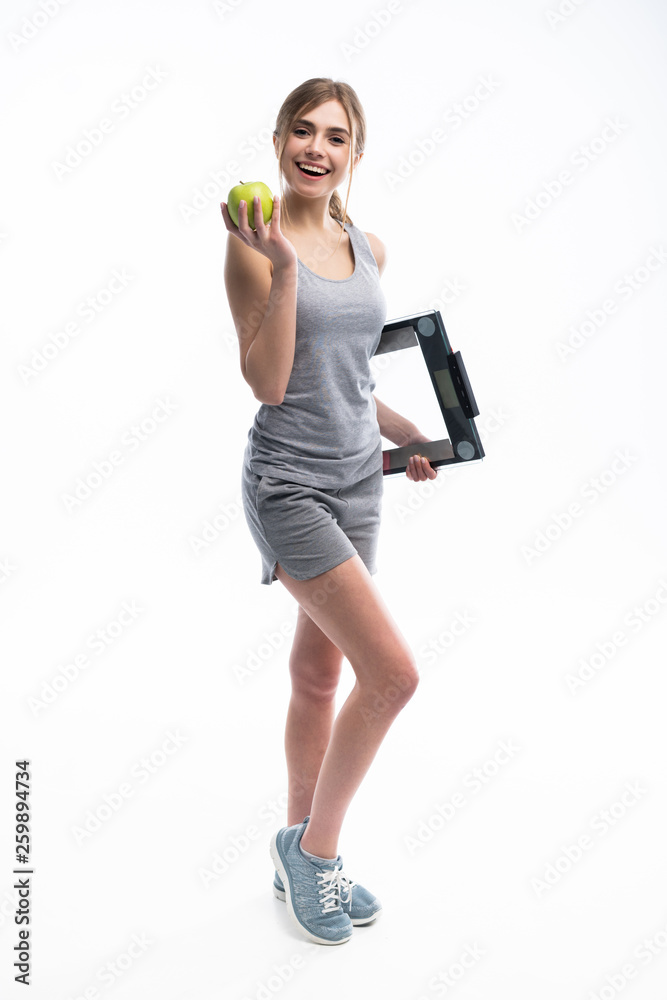 Healthy woman stands with the scales and green apple. Healthy eating concept. Healthy woman stands with the scales and green apple. Healthy eating concept.