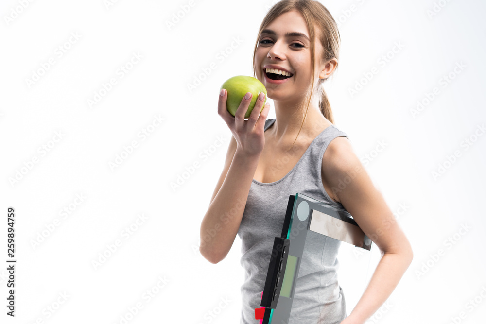 Healthy woman stands with the scales and green apple. Healthy eating concept. Healthy woman stands with the scales and green apple. Healthy eating concept.