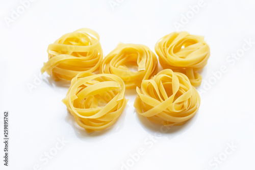 Italian pasta tagliatelle nest on white