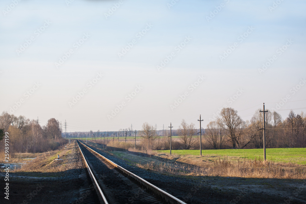 The railway at sunset, runs near an agricultural field, a spring landscape. The railway at sunset, runs near an agricultural field, a spring landscape.