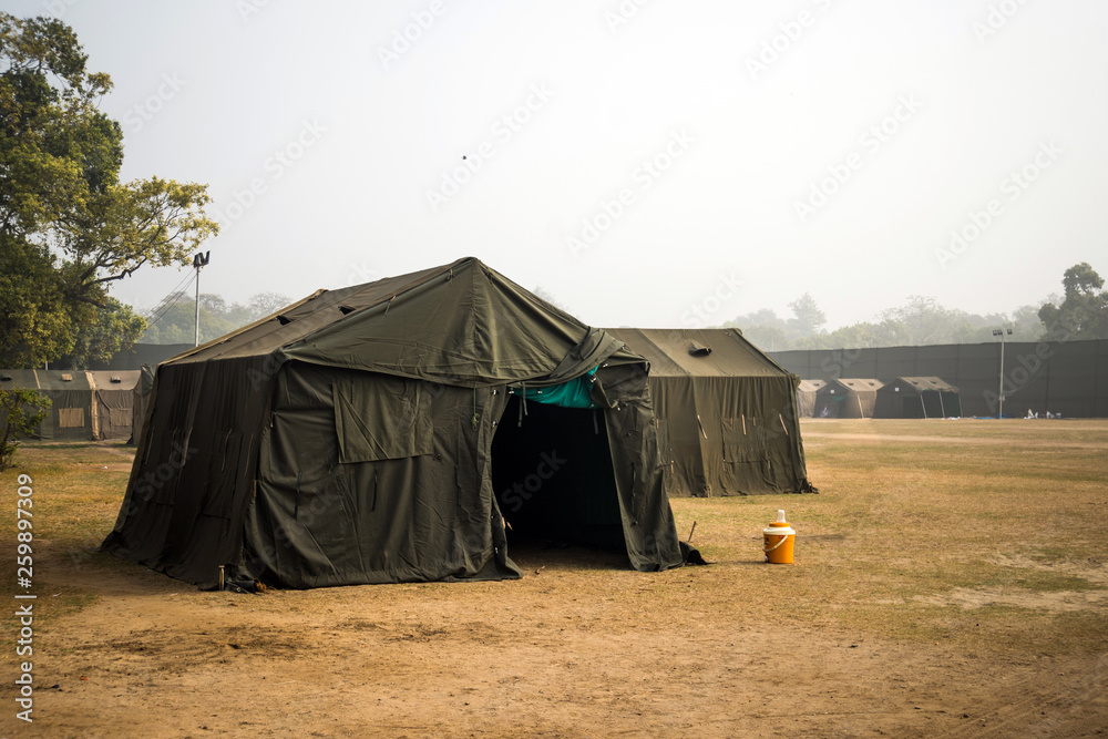 Military tent in the field. big tent city. field camp in nature. military  base with temporary barracks. military exercises of the soldiers. large military  tent. Army camp. reconstruction warfare. Stock Photo