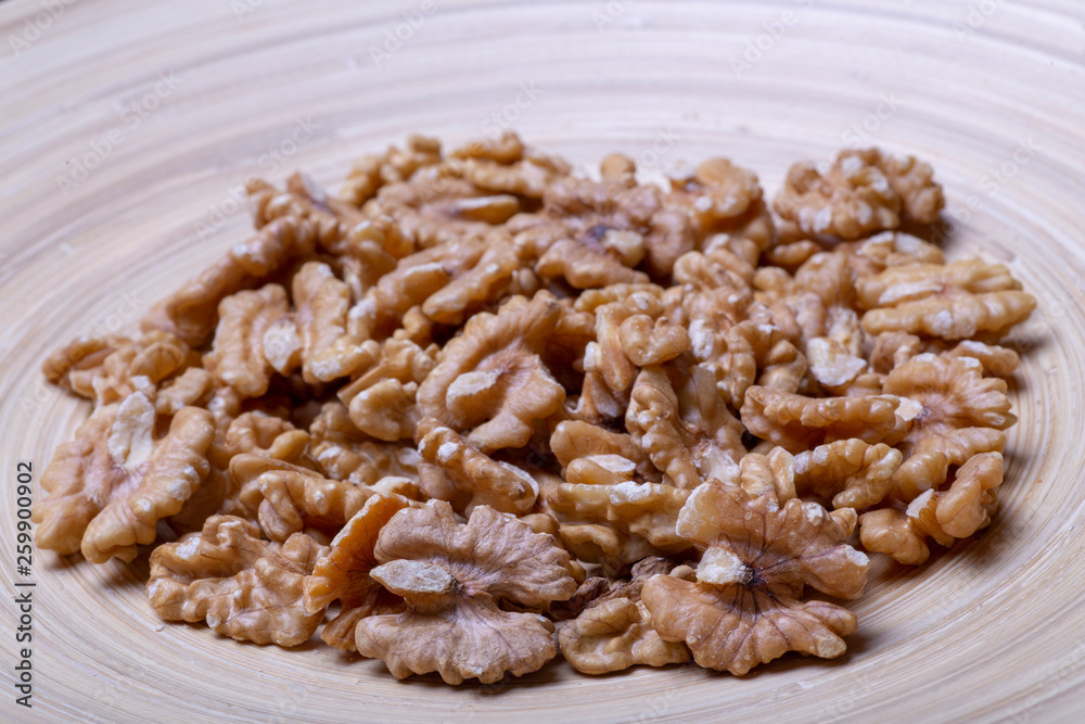 Walnuts on the wooden plate on the table Walnuts on the wooden plate on the table