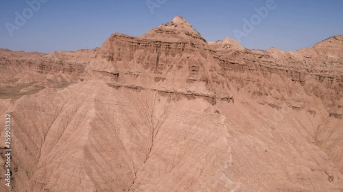 Aerial flight in the desert over sharp sandy cliffs, mountains. Panoramic view. Iran.
