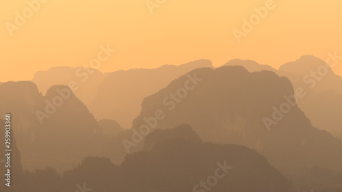 Landscape view of silhouettes and shapes of mountains and hills in asia in orange sunset time