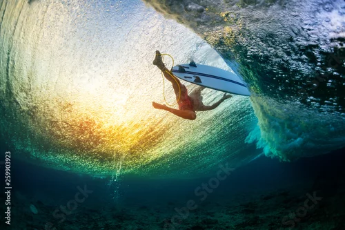 Obraz Podwodny widok surfera unoszącego się na powierzchni wody po przejściu dużej fali