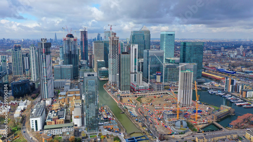 Aerial drone shot from iconic Canary Wharf skyscraper business and financial area with lots of clouds  Docklands  Isle of Dogs  London  United Kingdom