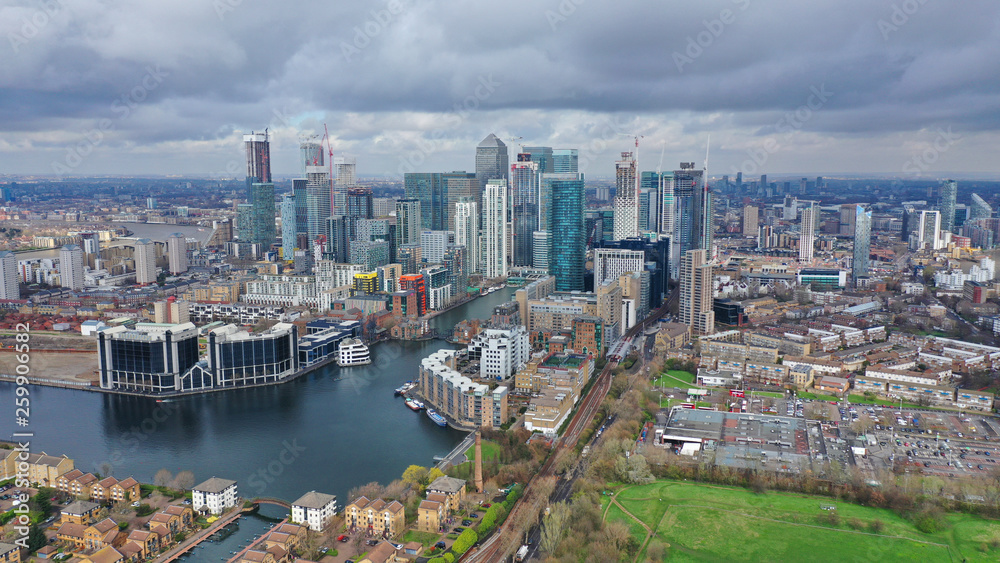 Aerial drone shot from iconic Canary Wharf skyscraper business and financial area with lots of clouds, Docklands, Isle of Dogs, London, United Kingdom