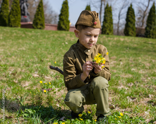 Photography Little boy in military uniform with flowers on 9 may