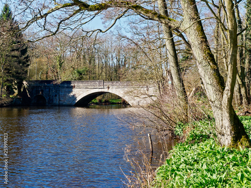 River Derwent flowing under the arches of the old Froggat Bridge on a spring day.