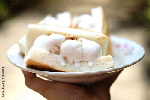 Hand holding Coconut ice cream with bread