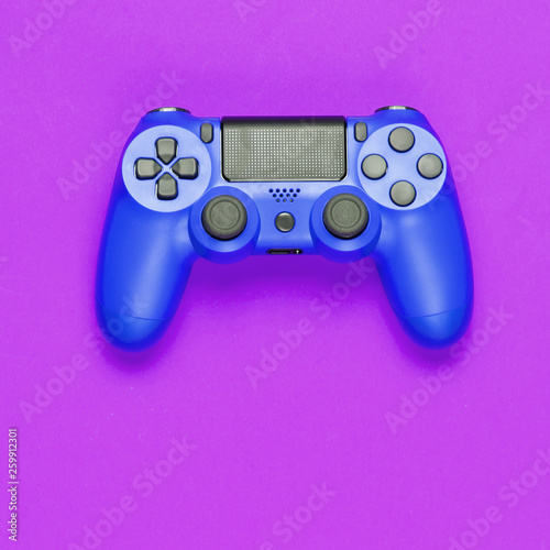 Modern blue gamepad (joystick) on purple background. Top view.
