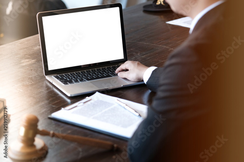 Man working by using a laptop computer on wooden table. Hands typing on a keyboard.