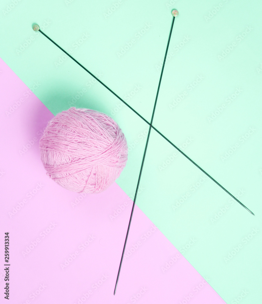 Knitting needles, skeins of wool on a pink-blue pastel background. Top view. Minimalism. . Knitting needles, skeins of wool on a pink-blue pastel background. Top view. Minimalism. .