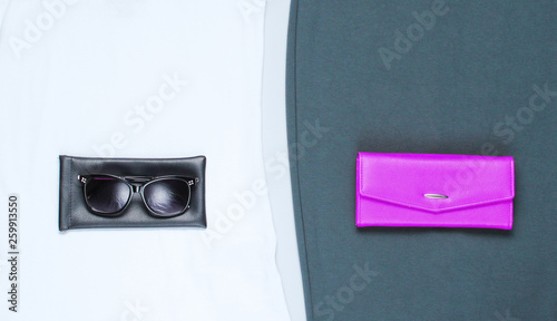 Women's fashion clothing and accessories on a gray background. Skirt, T-shirt, wallet, sunglasses. Flat Lay style.