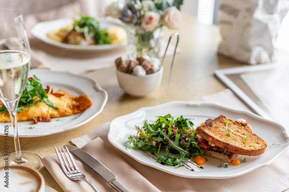French toast brioche, Sandwich with pastrami and sun-dried tomatoes. Light morning Breakfast, fresh warm pastries on table in restaurant French toast brioche, Sandwich with pastrami and sun-dried tomatoes. Light morning Breakfast, fresh warm pastries on table in restaurant