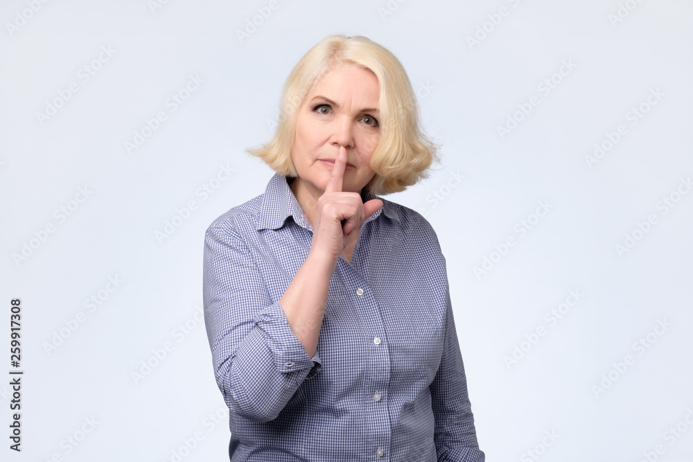 Serious lovely blonde woman asks to keep secret information confidential Serious lovely blonde woman asks to keep secret information confidential